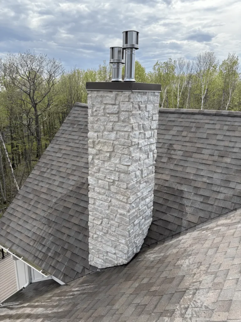 Brick and stone chimney on a traditional home with neatly layered masonry