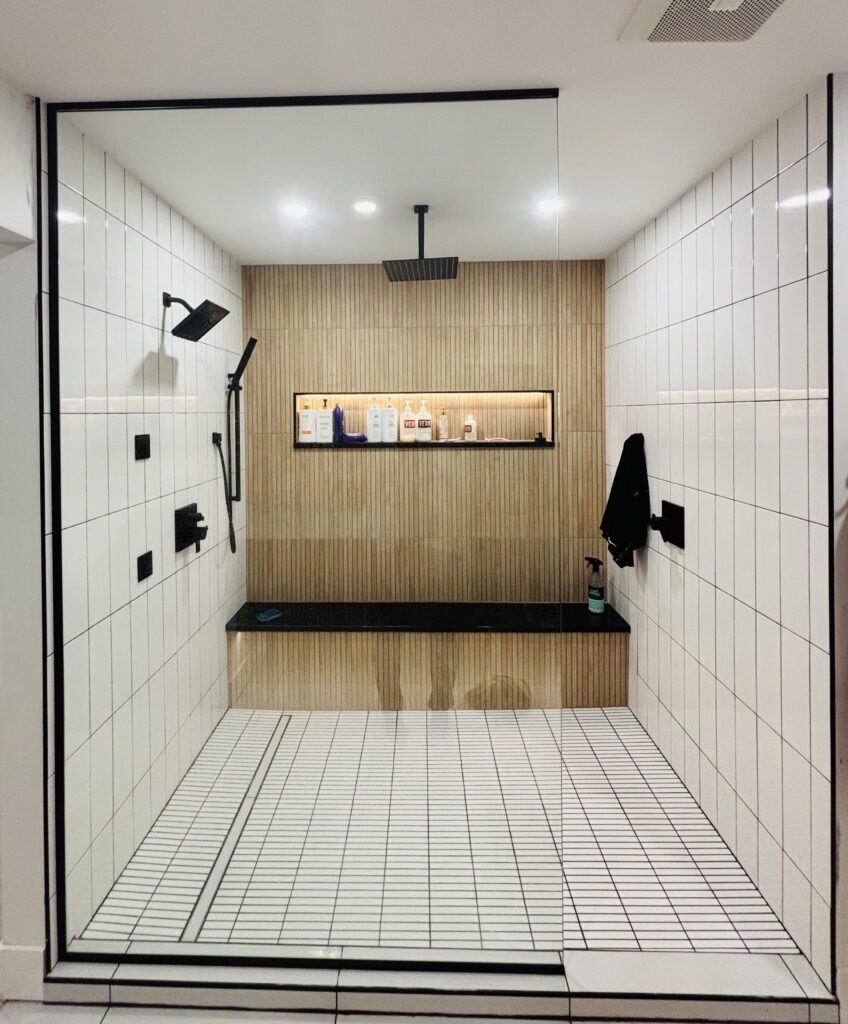 A custom tile walk-in shower with wood-like tile back wall